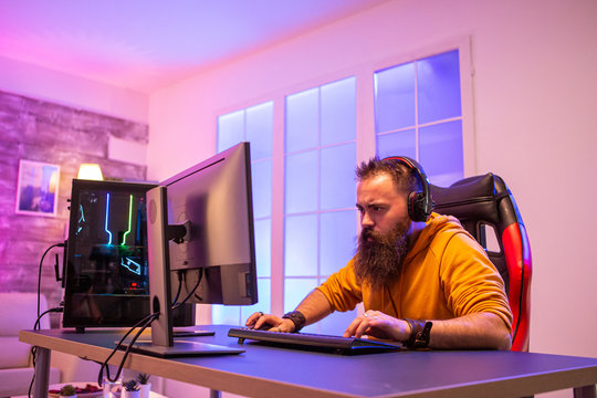Professional gamer with long beard in front of powerful gaming rig