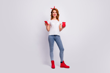 Full length body size view of her she nice attractive cheerful cheery girl holding in hand punch cup drinking beverage using 5g spending free time isolated over light white pastel color background