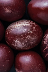 Easter eggs painted in monochrome style isolated on dark , in dark plum blossom color with white...