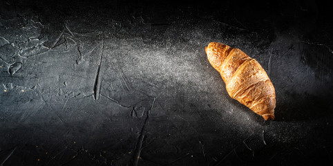 Fresh french croissants on dark background. Top view with copy space