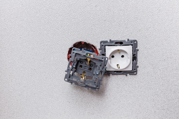 Two sockets on a white wall. Installation of sockets. Home repairs. Close-up.