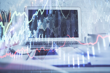 Stock market graph and table with computer background. Double exposure. Concept of financial analysis.