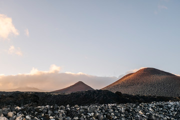 Sunset landscape of mountains and volcanic rock soil