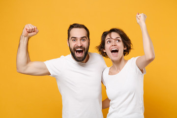 Joyful young couple friends bearded guy girl in white empty blank t-shirts posing isolated on...