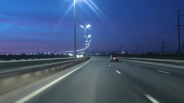 Driving Car POV On Freeway In Of Night In With Little Traffic After Sunset. Evening Sunset Street Lights. Night, Camera In Front, Windshield Reference. Driving Car On Highway At Dark 4K POV.