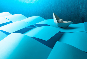 Paper ship in the paper sea. Concept of the theme of bureaucracy.