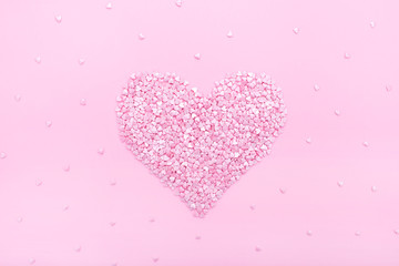 Pink background. Pink hearts on a pink background. Hearts sprinkles. Valentine day. Flat lay style. Top view. Sweet background. Confetti.