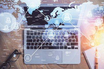 Computer on desktop with social network theme icon. Multi exposure. Concept of international connections.