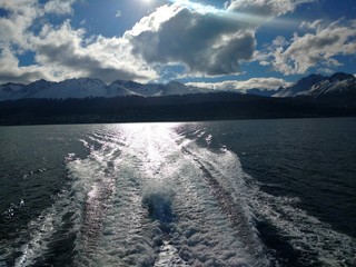 eagle Channel at sunset with a trail of the boat engine, with the snowy Andes Mountains in the background