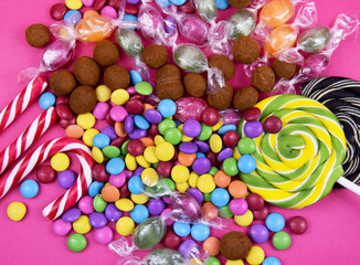 Fototapeta na wymiar Colorful candies on a pink background stock images. Sweets on pink background. Mix of candies top view. Various colorful candies and sweets stock images. Candies and lollipops images