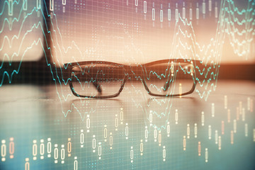 Financial graph hologram with glasses on the table background. Concept of business. Double exposure.