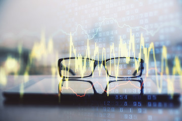 Financial graph hologram with glasses on the table background. Concept of business. Double exposure.