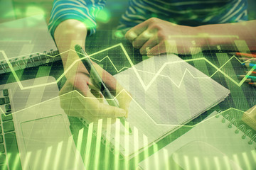 Financial chart drawn over hands taking notes background. Concept of research. Double exposure