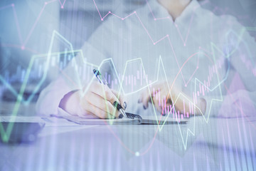 Financial chart drawn over hands taking notes background. Concept of research. Multi exposure