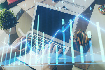 Double exposure of stock market graph with man working on laptop on background. Concept of financial analysis.