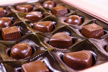 Heap of chocolate candies in a brown box