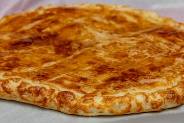 Homemade Twelfth Night cake (french galette des rois) made of puff pastry, with the charm inside.