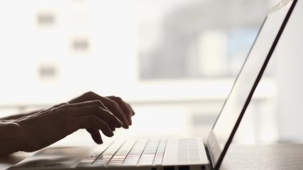 Woman working with laptop on Desktop Next to Window. Woman Blogger Freelancer Working on Laptop at Home Office. Close Up Female Hands Using Keypad. Businesswoman Scrolling News Feed Online at Work.