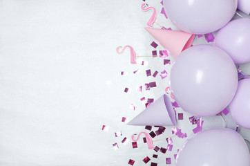 Concept of party time. Beautiful ballons, confetti, flamingo decor,party hats on the bright wrapping paper. Empty space for text