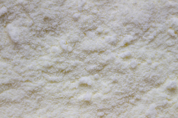Texture of yellow dry baby food, milk powder. Close-up, macro