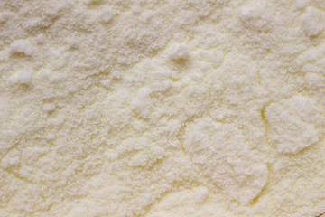 Milk powder for baby in pink measuring spoon. Dry baby food, close-up