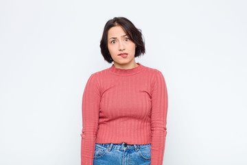 young pretty woman feeling clueless, confused and uncertain about which option to pick, trying to...