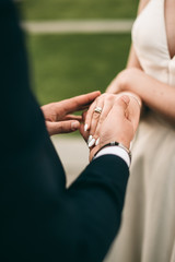 wedding rings on hands of bride and groom