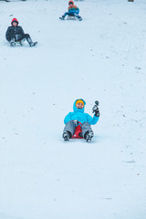 young woman sliding down by snowed hill