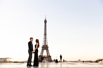 Fototapeta na wymiar Love in Paris. Romantic couple holding hands on the background of the Eiffel Tower. Honeymoon, date, wedding, marriage in France