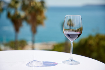 glass of red wine near sea