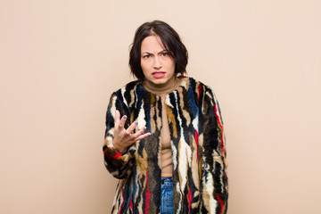 young pretty woman looking angry, annoyed and frustrated screaming wtf or what‚Äôs wrong with...