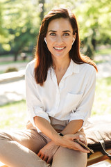 Happy attractive young woman relaxing on the bench