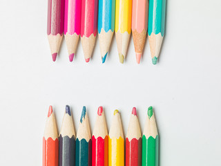 various colors of pencils on a white background, copy space