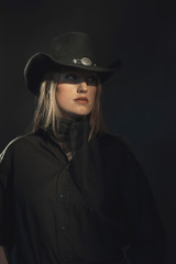 Blonde cowgirl in black shirt and hat.