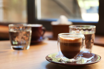 Aromatic coffee on wooden table in cafe. Space for text