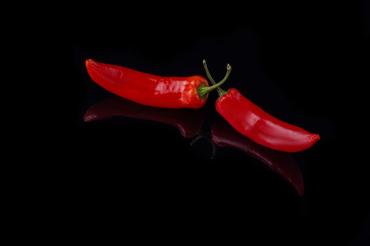 Red chili peppers and copy space. Hot red chili peppers on black background. Flat lay, copy space.