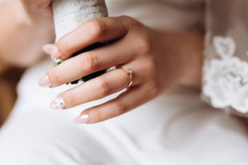 Bride's hand close up with a minimalistic engagement ring with a diamond