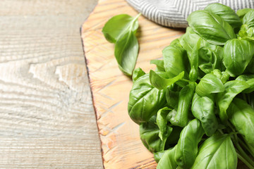 Fresh basil on wooden table, closeup. Space for text