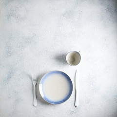 Obraz na płótnie Canvas White with blue empty plate with cutlery on marble table. Marble background. Copyspace. Top view.
