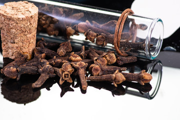 dried clove spice next to test tube and cork