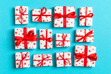 Fototapeta na wymiar Composition of holiday white gift boxes with red hearts on colorful background. Valentine's day concept