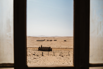 Abandoned buildings left to rot in wild west scenery with desert sand