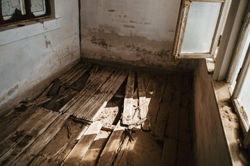 destroyed wooden floor with plans in a ruined house, concept photograph for renovating a house
