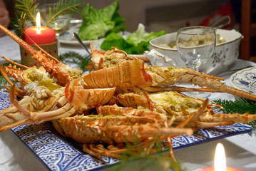 Cooked and cut lobsters on decorated dinner table.