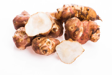 Raw Whole ans sliced Jerusalem artichokes on a white background