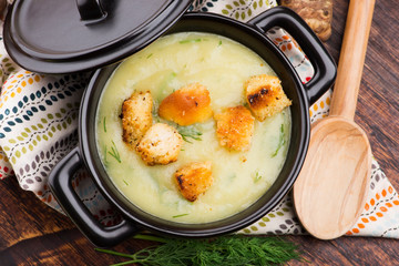 Creamy Jerusalem artichoke soup on wooden background