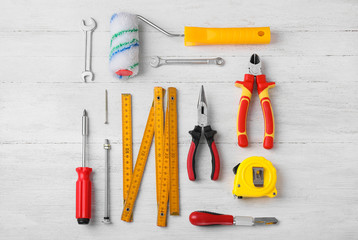 Flat lay composition with different construction tools on white wooden background