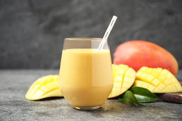 Fresh delicious mango drink on grey table