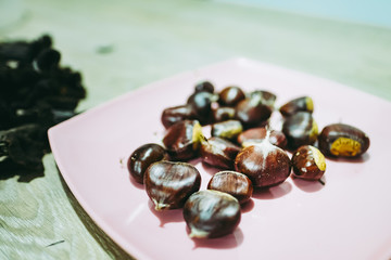 Châtaignes dans une assiette rose prêtes à cuire