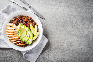 Healthy dish with quinoa, chicken, avocado, lime on concrete background top view. Food and health. Superfood meal.	